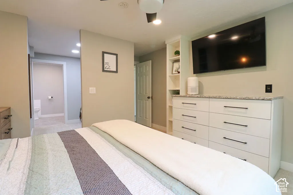 Built-in cabinetry with a stone countertop and integrated shelving, recessed lighting, and a ceiling fan