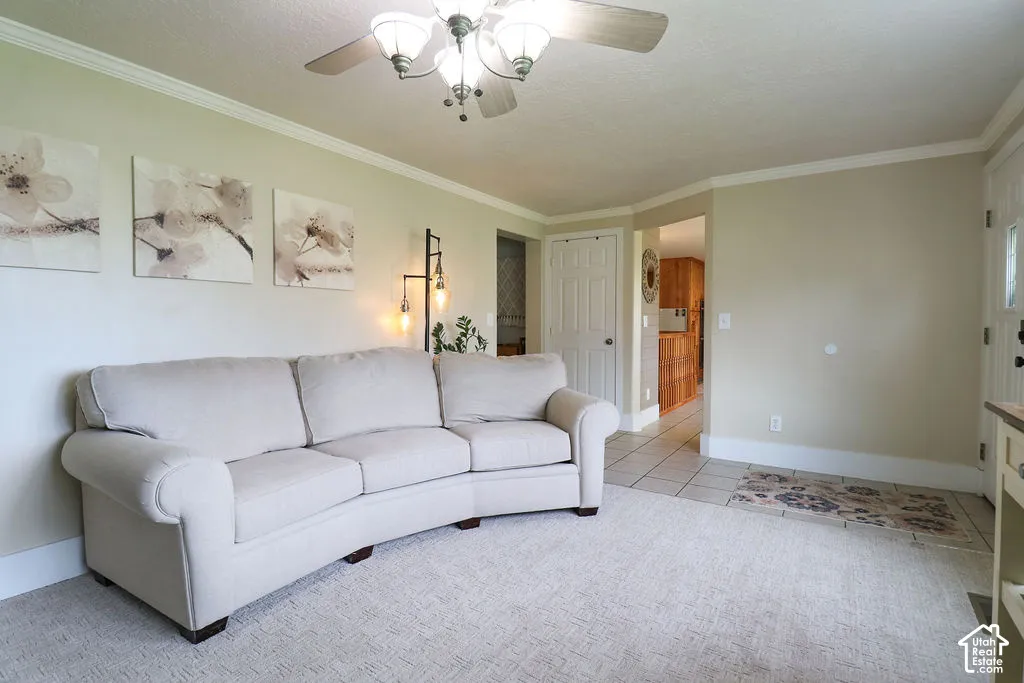 Recessed ceiling fan with integrated lighting, crown molding, light-toned walls, and tile flooring