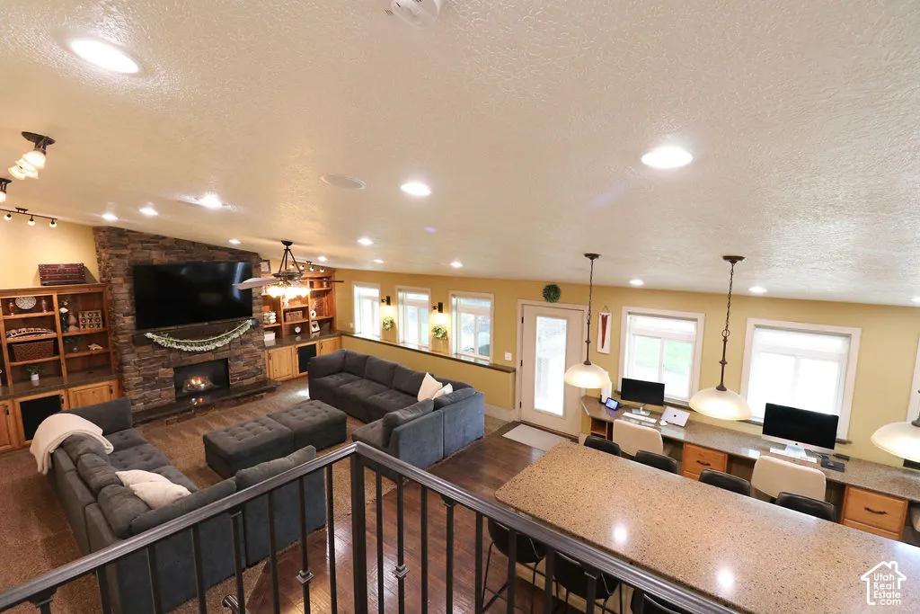 Spacious open-concept living area featuring a stone-clad fireplace and built-in shelving