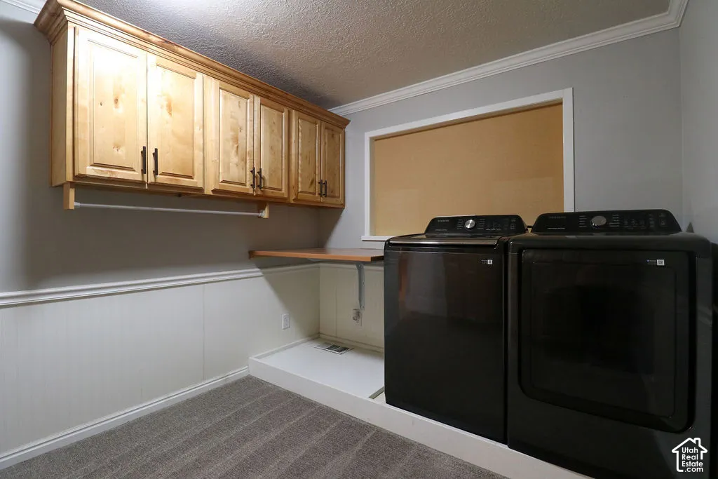 Wood-finish cabinetry, wainscoting detail, built-in folding surface, and crown molding