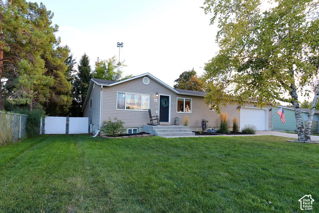 Siding exterior with multiple windows, concrete entry steps, an attached garage, and mature trees