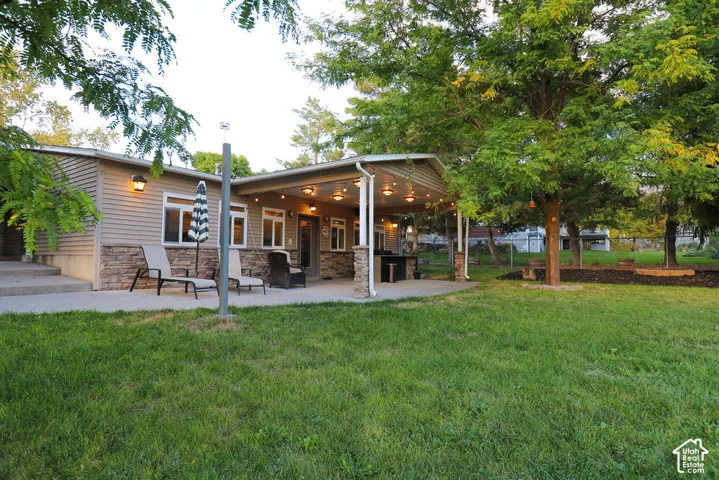 Covered patio with integrated lighting, a built-in outdoor counter, and stone-clad support columns
