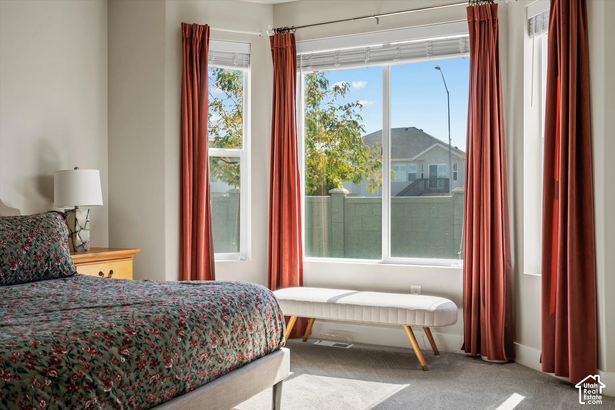 Large windows, light gray wall paint, and gray carpeting