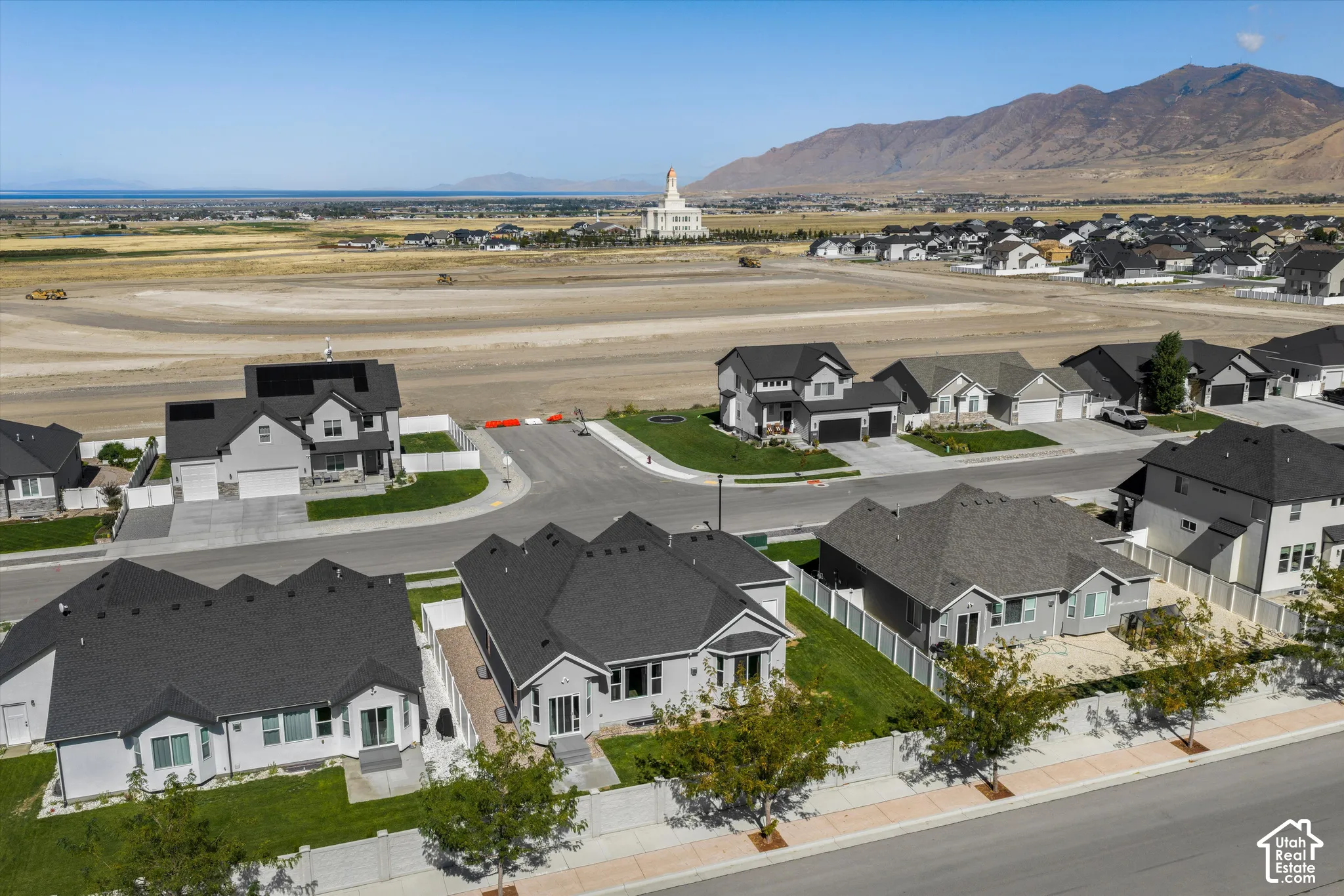 Newly constructed residential neighborhood with contemporary homes featuring dark shingle roofs, light-colored siding, and attached garages
