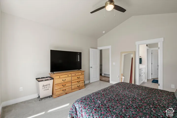 Vaulted ceiling with a ceiling fan, light gray wall paint, and gray carpet flooring