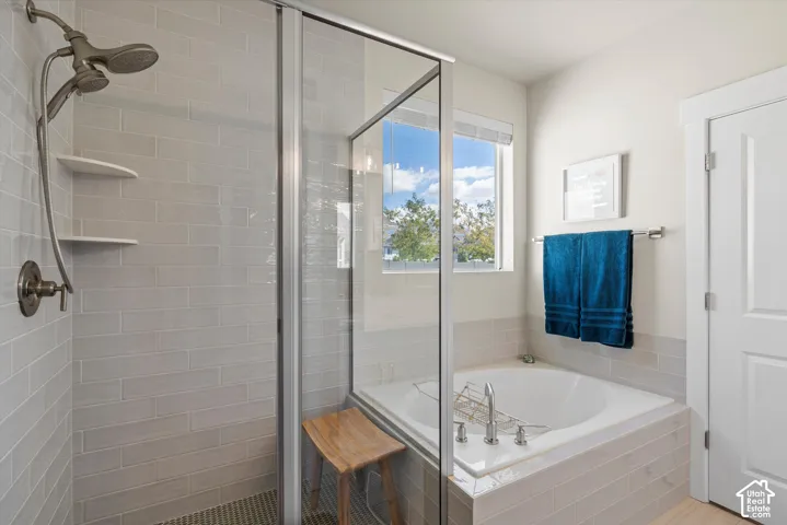 Glass-enclosed shower with subway tile surround and integrated shelving
