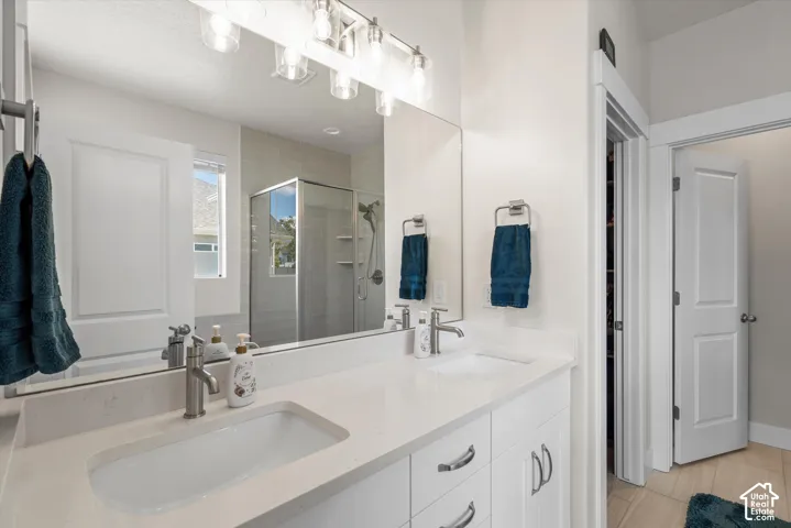 Double vanity featuring white cabinetry and light-toned countertops