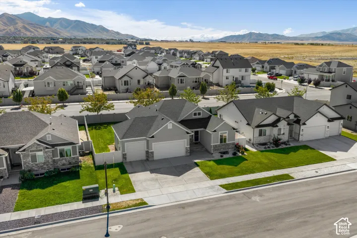 Single-story residence featuring a two-car garage, stone and siding exterior, and a well-maintained front lawn