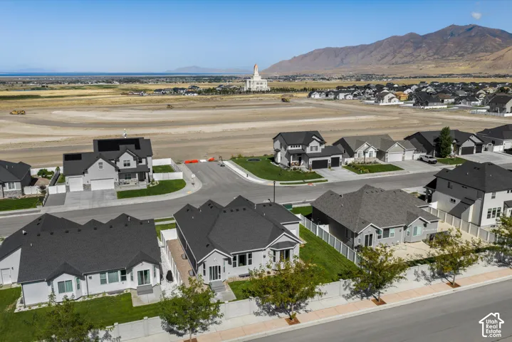 Newly constructed residential neighborhood with contemporary homes featuring dark shingle roofs, light-colored siding, and attached garages