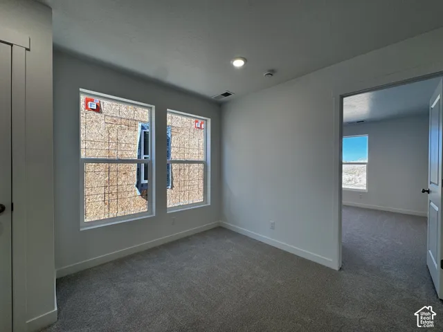 Recessed ceiling lighting, white interior doors, and neutral carpet flooring