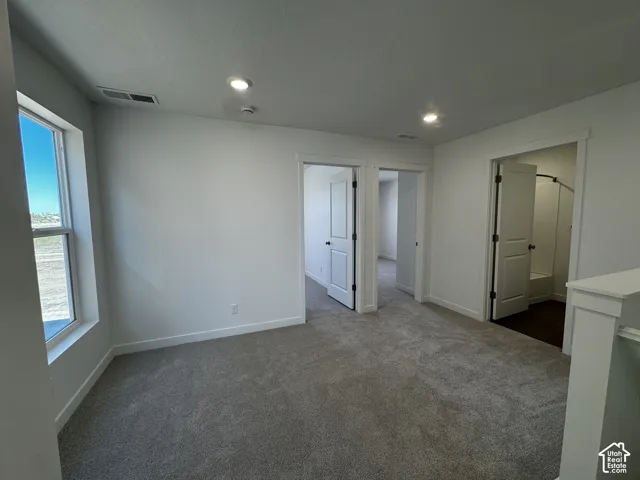 Gray carpeting, recessed lighting, white walls, and white trim