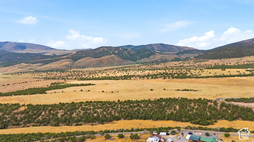 Expansive mountain terrain with varied natural vegetation and scattered residential structures