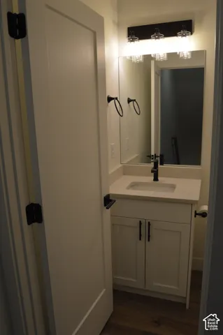 White vanity with shaker-style cabinetry, a light-toned countertop, and an undermount sink