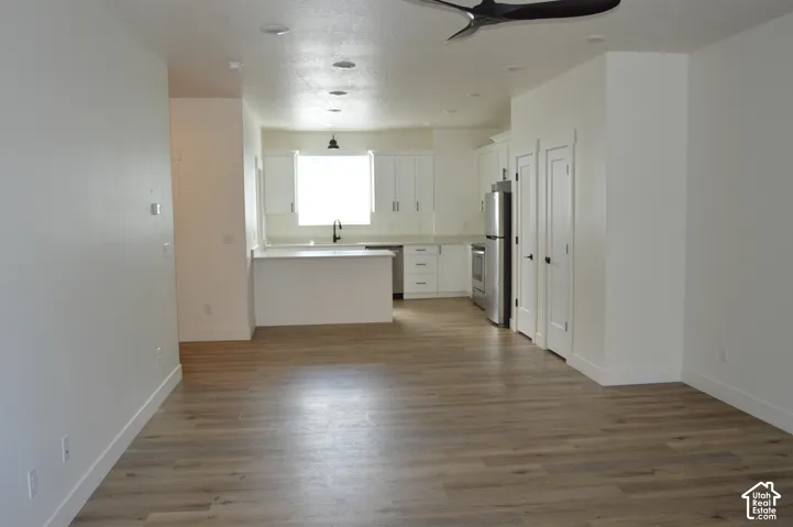 Open-concept living space with wood-finish flooring, recessed lighting, and a modern ceiling fan