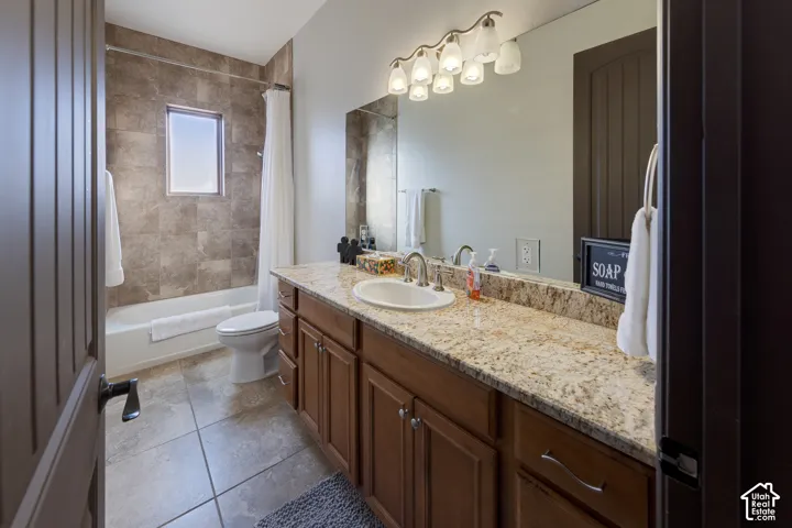 Vanity with a light-toned countertop, wood-finish cabinetry, and a full-width mirror