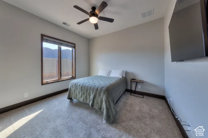 Recessed window with wood-finish trim, ceiling fan with integrated lighting, and wall-mounted television