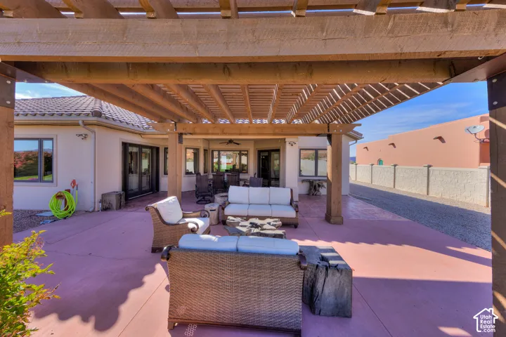 Expansive covered patio with a wood pergola, tile roof, and multiple windows