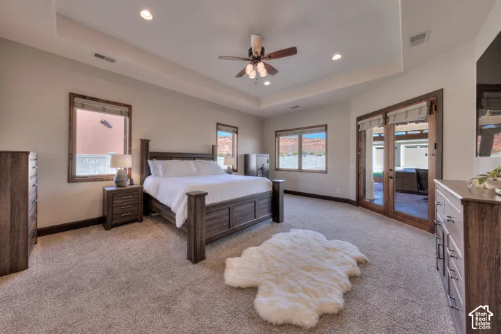 Recessed lighting, ceiling fan, tray ceiling, carpet flooring, and glass French doors