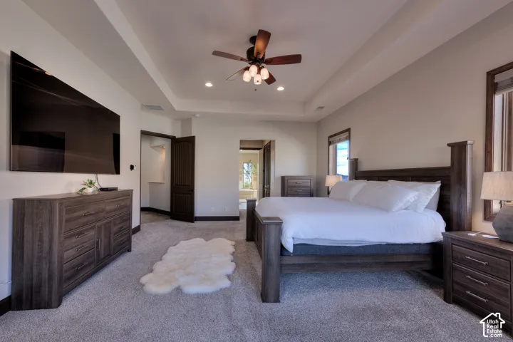 Tray ceiling with recessed lighting, ceiling fan with wood-finish blades, and wall-to-wall carpeting