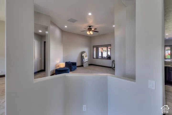 Spacious room featuring vaulted ceilings, recessed lighting, ceiling fan, and large windows