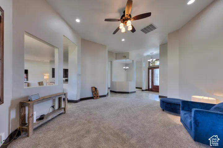 Vaulted ceiling with recessed lighting and a ceiling fan, carpeted flooring, wood-finish baseboards, and interior wall cutouts