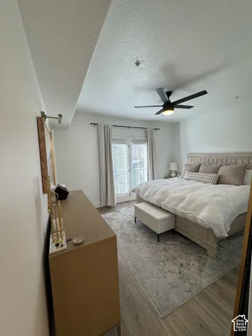 Wood-finish flooring, ceiling fan with integrated lighting, and white walls