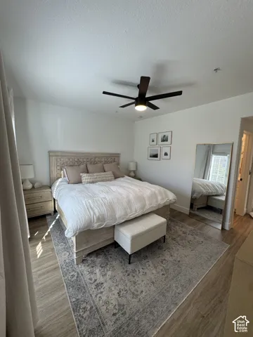 Wood-finish flooring, ceiling fan with integrated lighting, and neutral wall tones