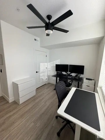 Recessed lighting with a ceiling fan, wood-finish flooring, and white interior door with dark hardware