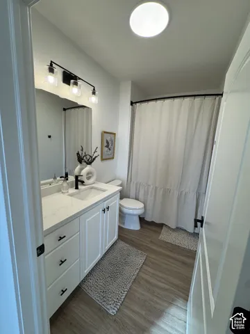 White vanity with black hardware, white countertop, and integrated sink