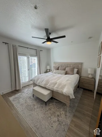 Modern ceiling fan with integrated lighting, wood-finish flooring, and white walls