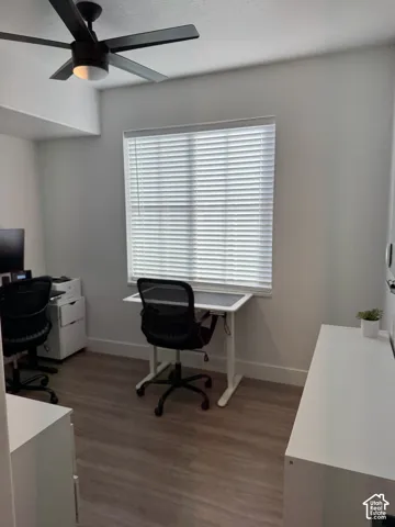 Wood-finish flooring, white walls, and a window with horizontal blinds