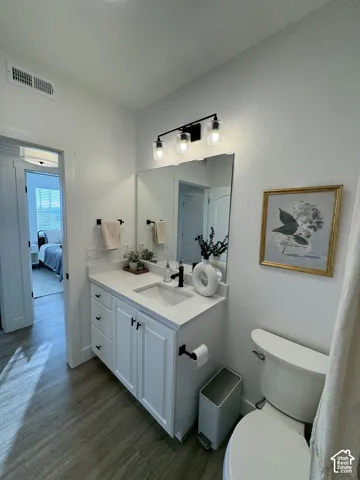 White vanity with shaker-style cabinetry, an integrated sink, and a black single-handle faucet