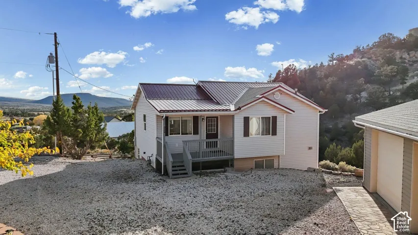 White siding exterior with a dark metal roof and front porch