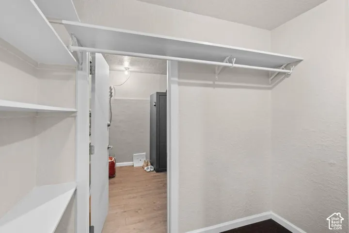 Integrated closet shelving, white hanging rod, and textured interior walls