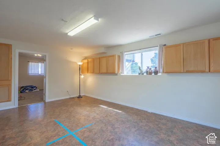 Recessed lighting, wood-finish flooring, built-in cabinetry, and a large window