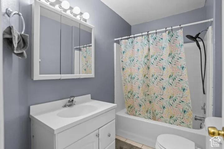 Bathroom featuring a white vanity with integrated sink, chrome faucet, and a wall-mounted medicine cabinet with integrated lighting