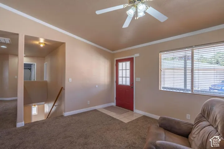 Inviting entry with a red panel door featuring divided lites, adjacent to a large window with blinds