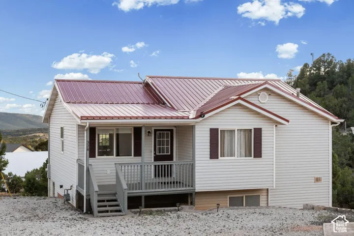 White siding exterior with a red metal roof