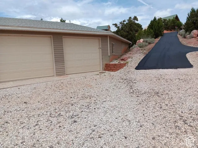 Attached two-car garage with panel doors and horizontal siding