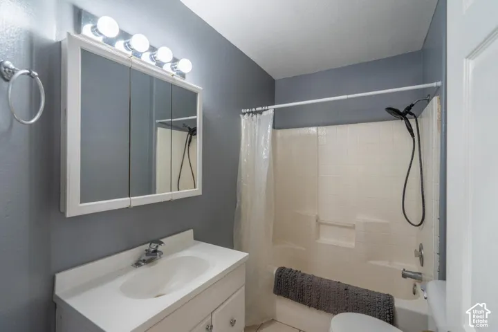 White vanity with integrated sink, chrome faucet, and cabinet storage