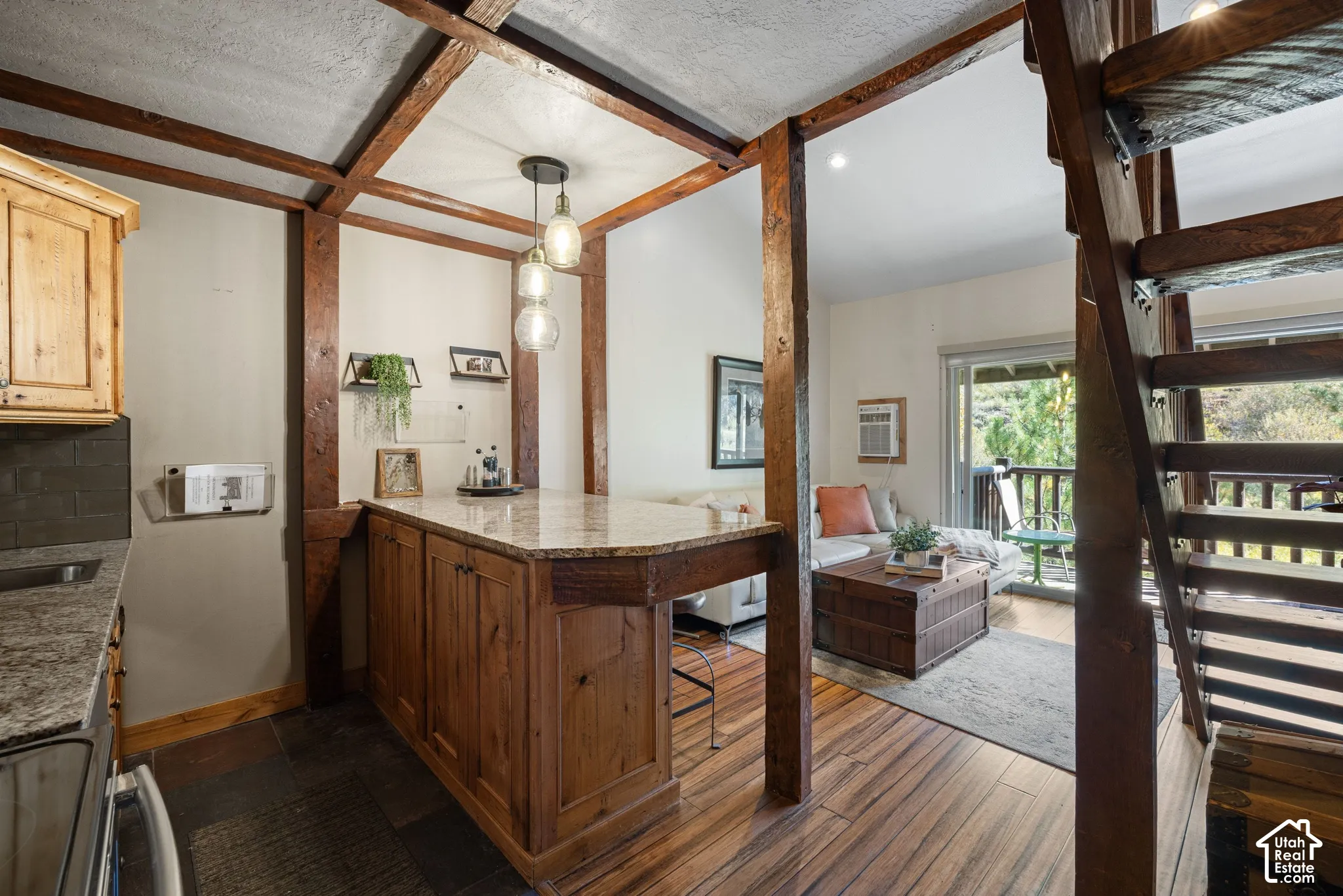 Exposed wood beams, wood-finish flooring, wood cabinetry, stone countertops, and a built-in staircase