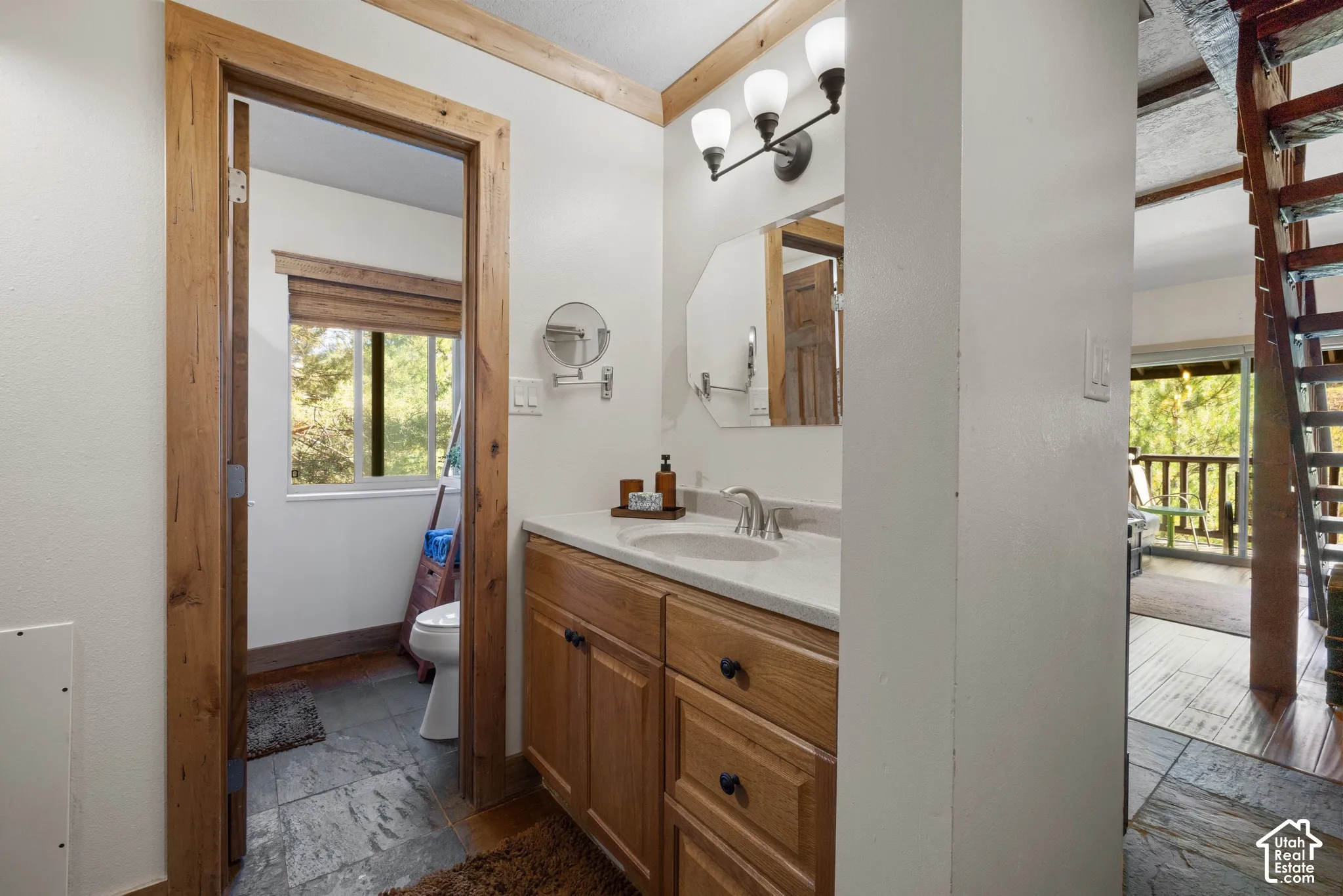 Bathroom featuring a wood-finish vanity with a white countertop and undermount sink