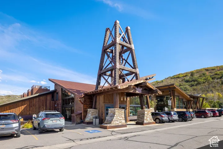 Expansive commercial property featuring a striking architectural design with a prominent wooden tower element, rich wood siding, and large glass storefronts