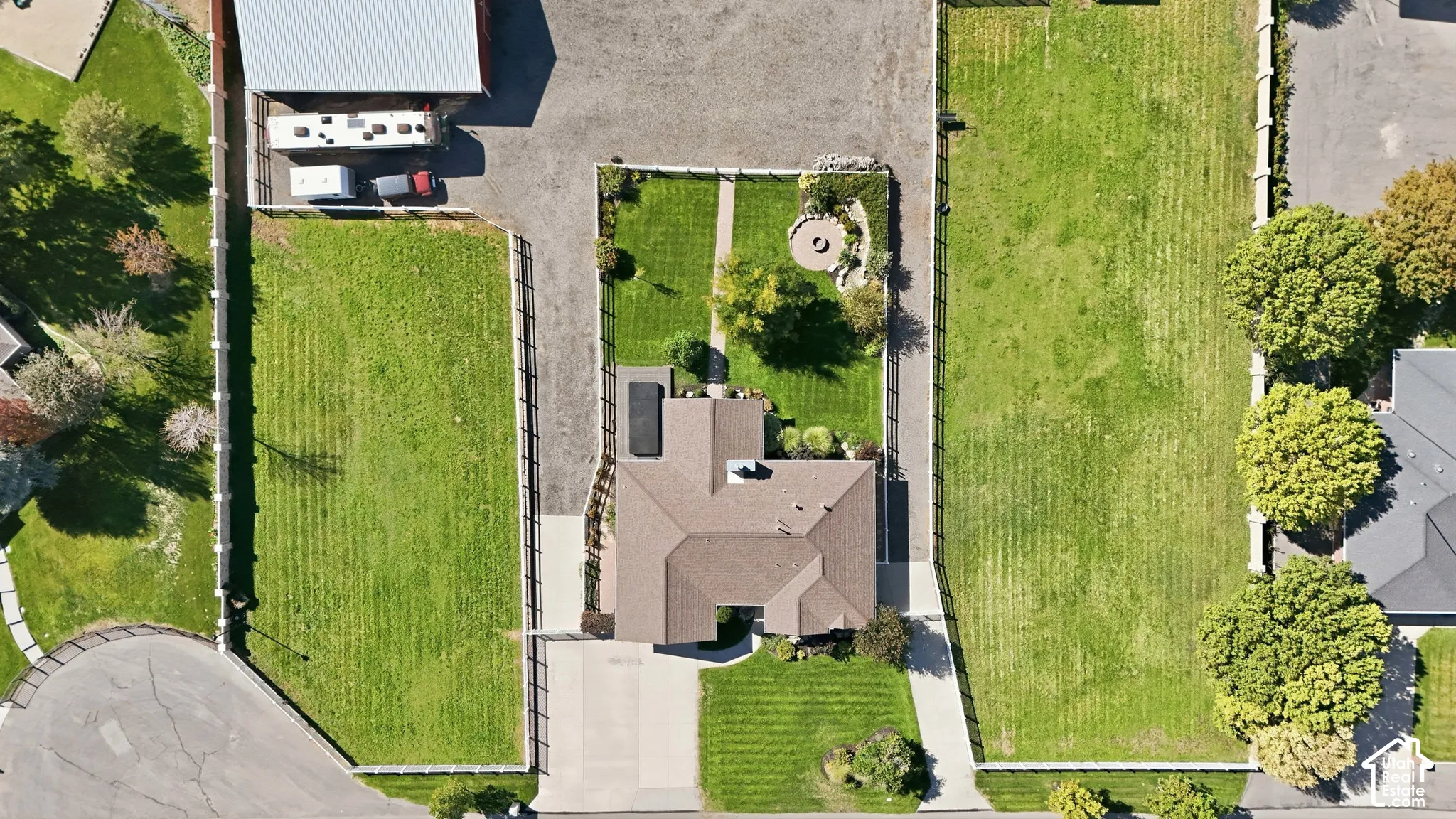 Expansive property featuring a central residence, a paved driveway, and multiple fenced grassy areas