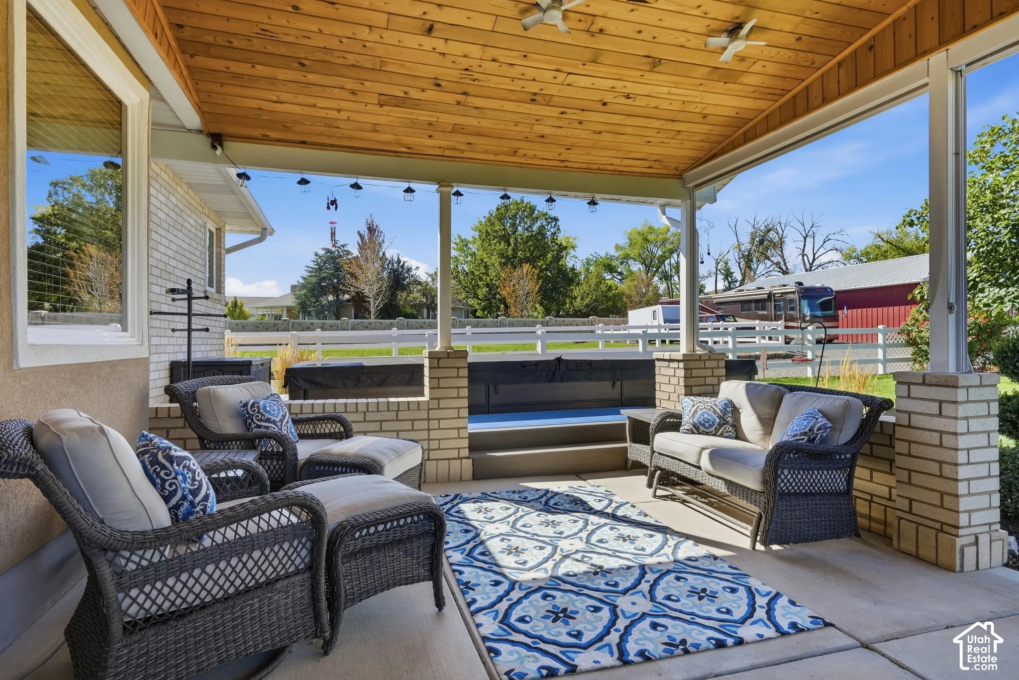 Covered patio with a wood-plank ceiling, ceiling fans, recessed lighting, and string lights