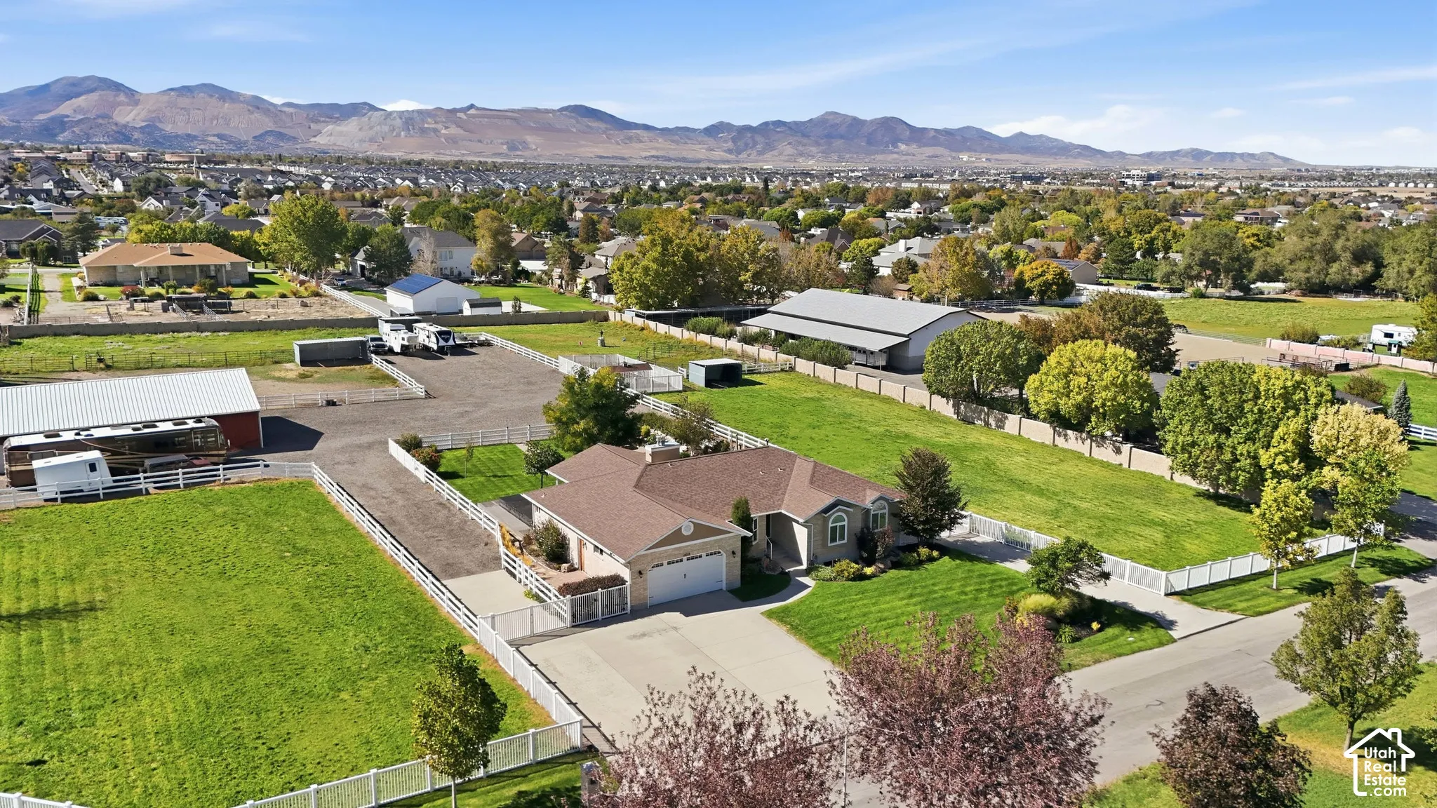Expansive lot featuring a single-story residence, attached garage, and multiple outbuildings