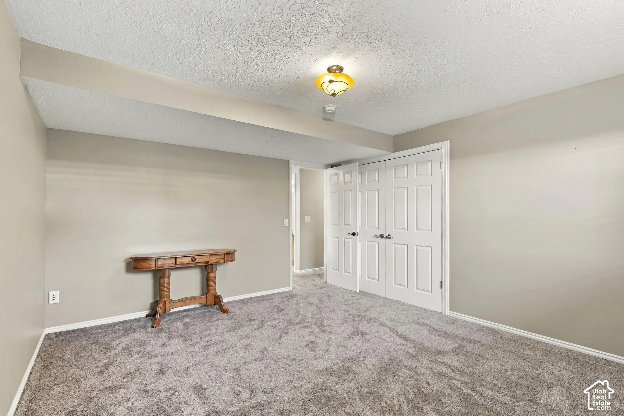 Wall-to-wall carpeting with light-toned walls, white trim, and a semi-flush mount ceiling light