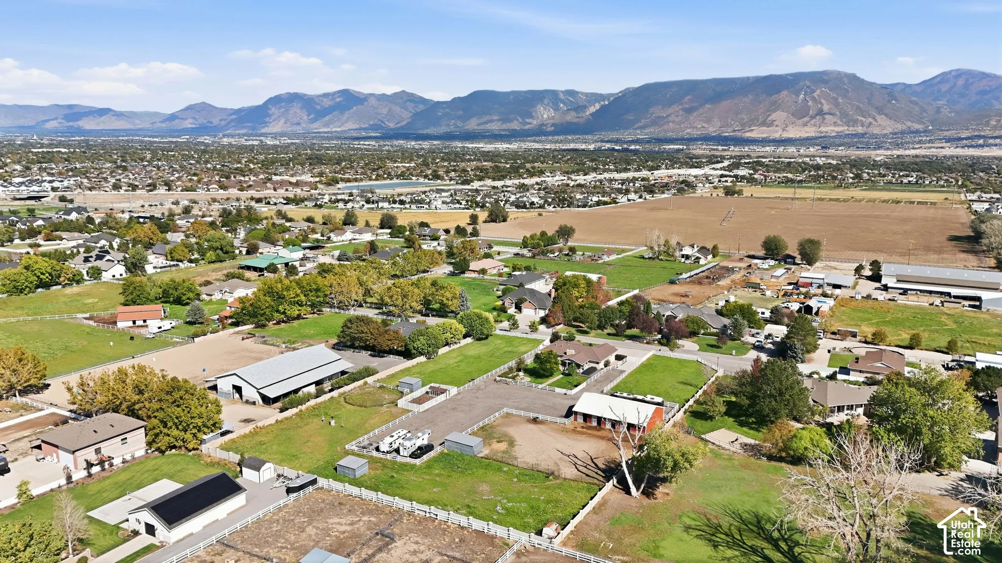 Expansive property featuring multiple structures, open land, and surrounding mountain ranges