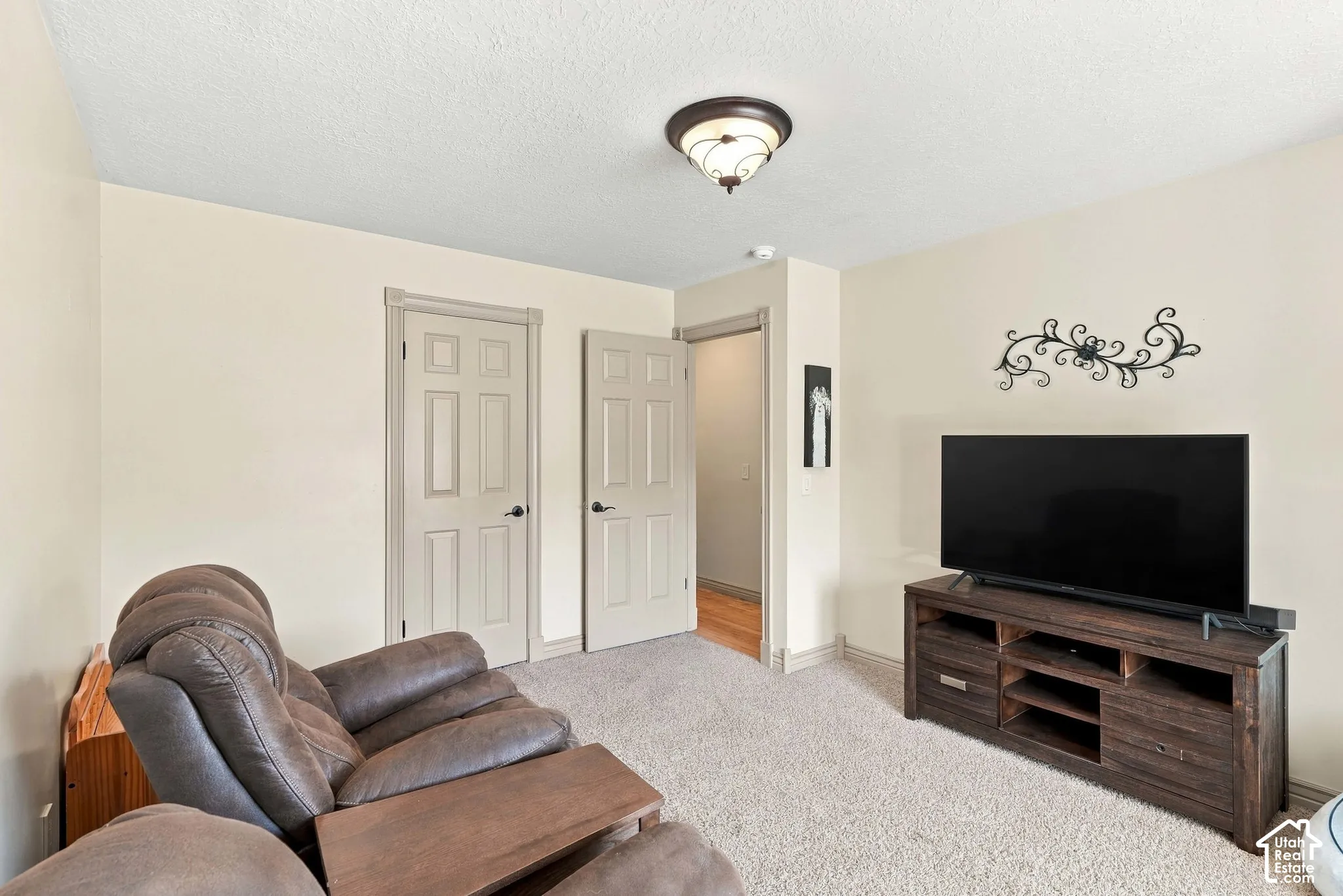 Neutral wall paint, carpeted flooring, two paneled interior doors, and a semi-flush mount ceiling light