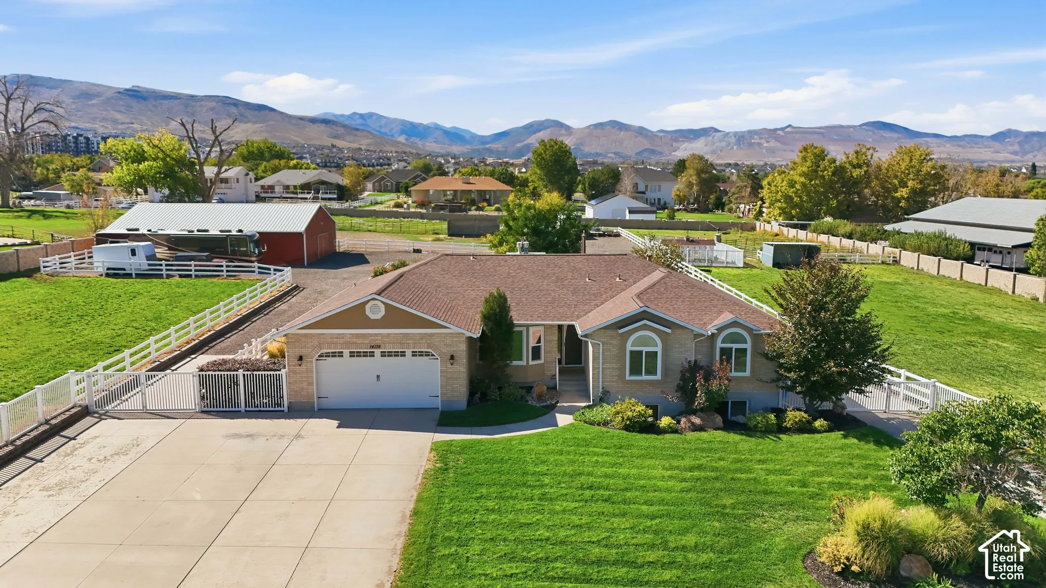 Single-story residence with a two-car garage, established landscaping, and a fenced perimeter